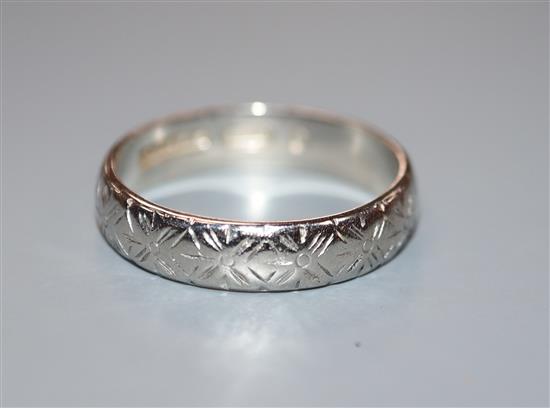 An engraved platinum wedding band, size O.